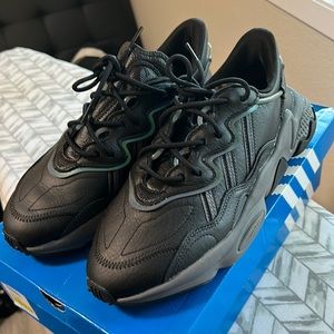 Adidas Ozweego black with some reflective hints. Never worn size 9.5 mens